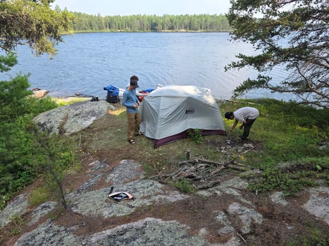 A tent pitched on a rocky point above a lake