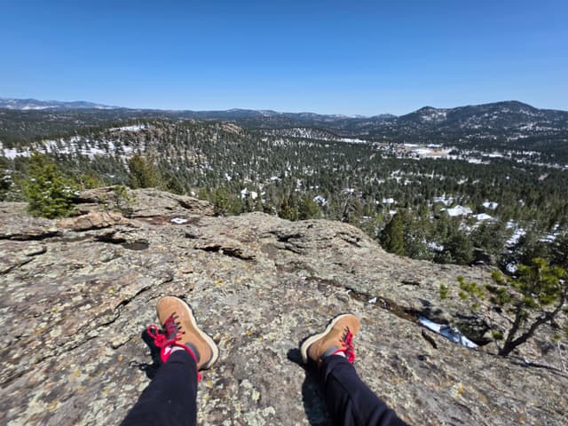 Feet up on a granite outcrop above a forested valley