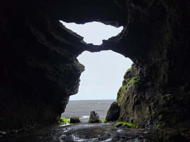 Looking out of a dark sea cave toward the ocean