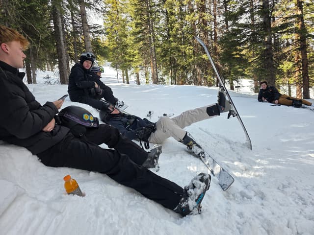 Friends taking a break in the snow between runs
