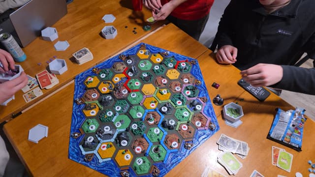 A game of Catan in progress on a wooden table