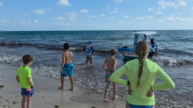 Kids standing in the surf on a Caribbean beach