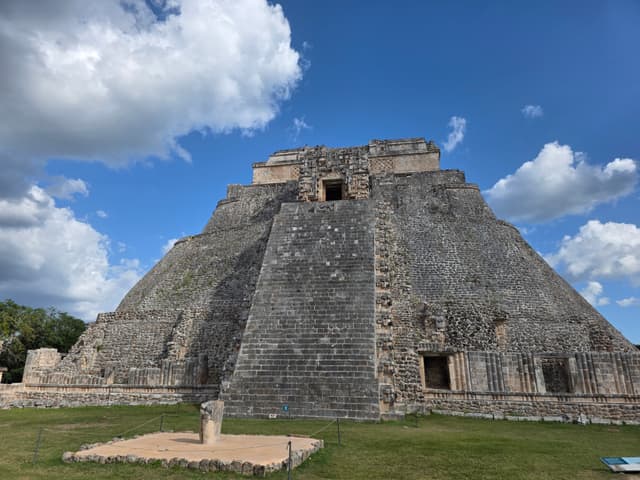 The Pyramid of the Magician under a blue sky with puffy clouds